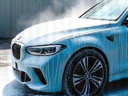 Car getting a foamy exterior wash.